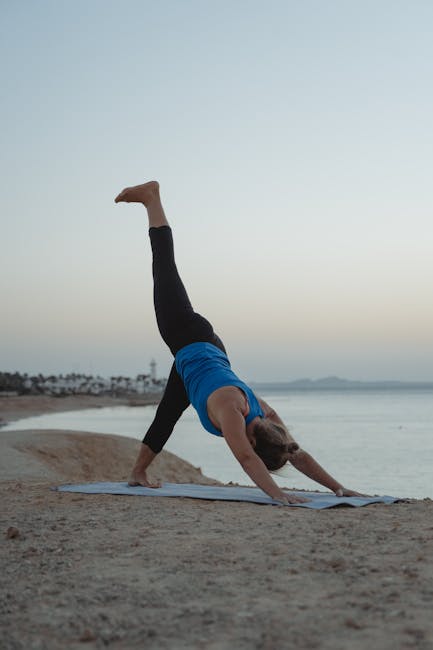 A woman in a peaceful yoga pose on a paddleboard with a sunset in the background